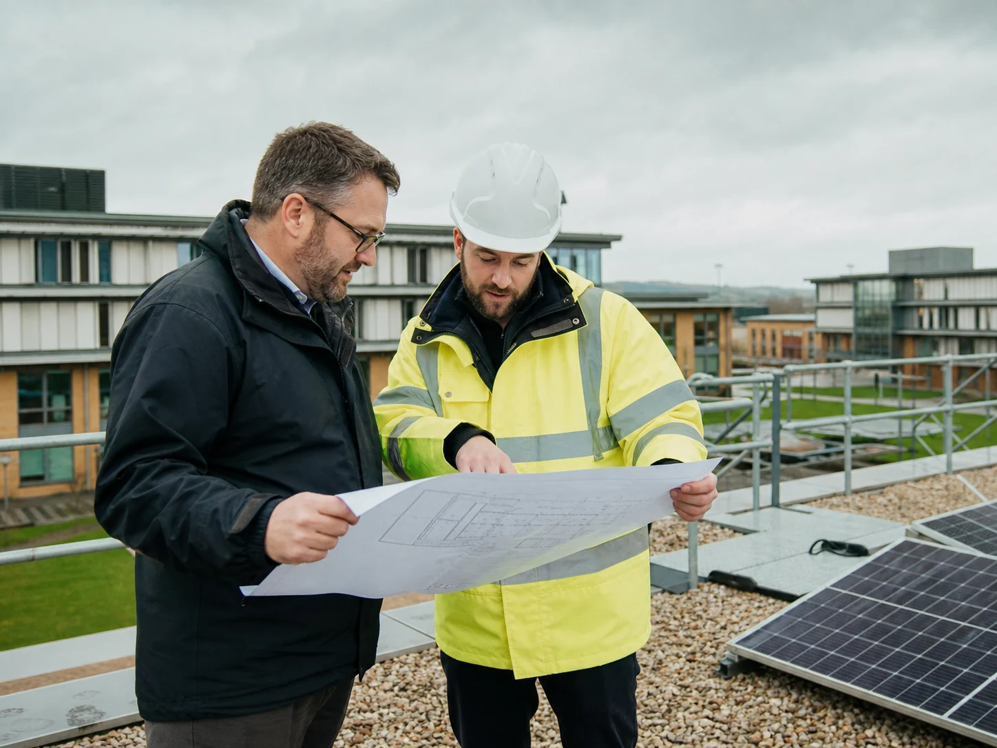 Facilities director and renewable energy engineer reviewing plans on a UK education estate